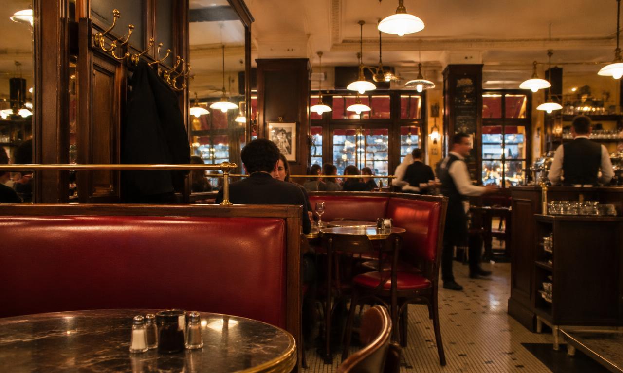 La salle de la fin d'après-midi, quand les banquettes rouges gardent la chaleur des conversations.
